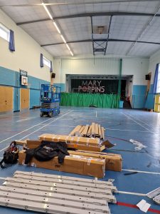 Bristol school hall during LED lighting work, with ceiling fittings and a scissor lift